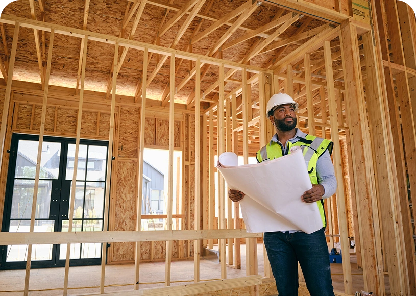 Engineer inspecting construction site with plans.