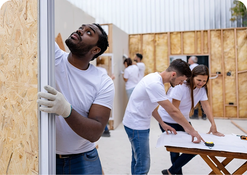 Volunteers constructing a house frame